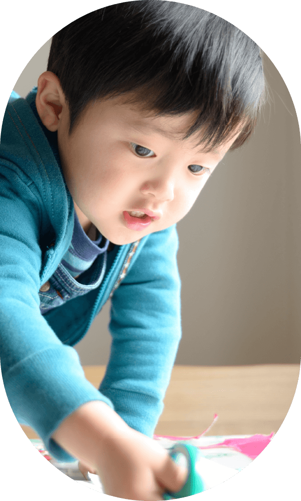 テーブルで集中する青い服の男の子